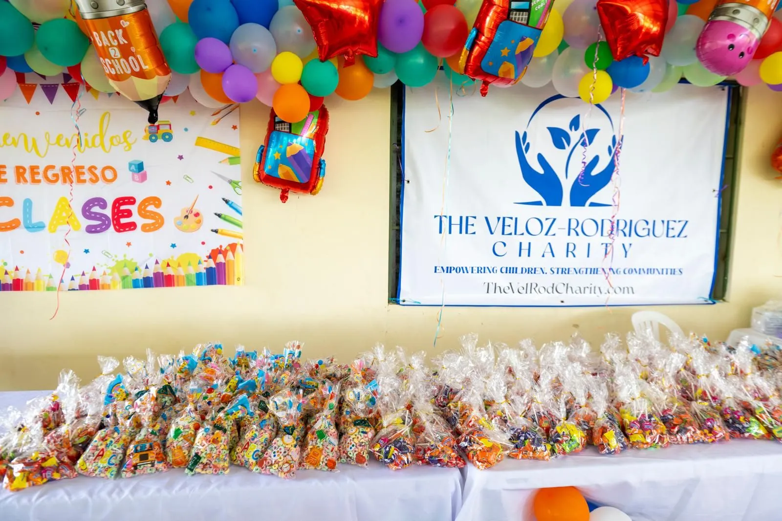 Treat bags lined up beneath The Veloz-Rodriguez Charity banner