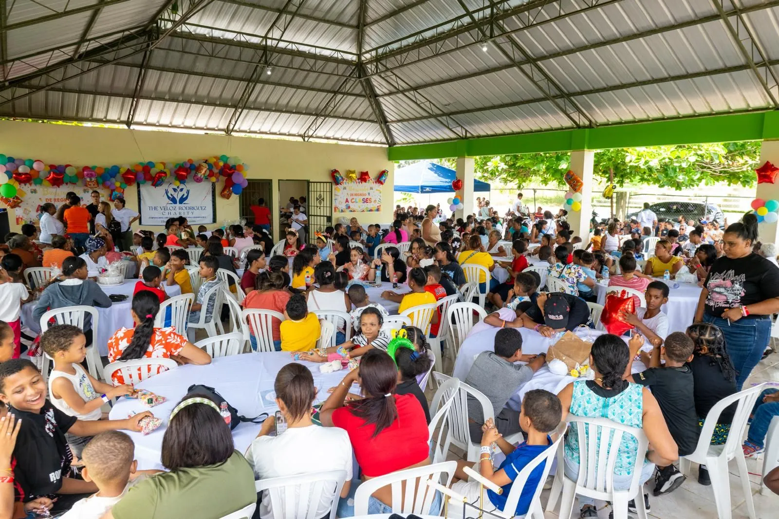 Families seated for the community meal under the pavilion