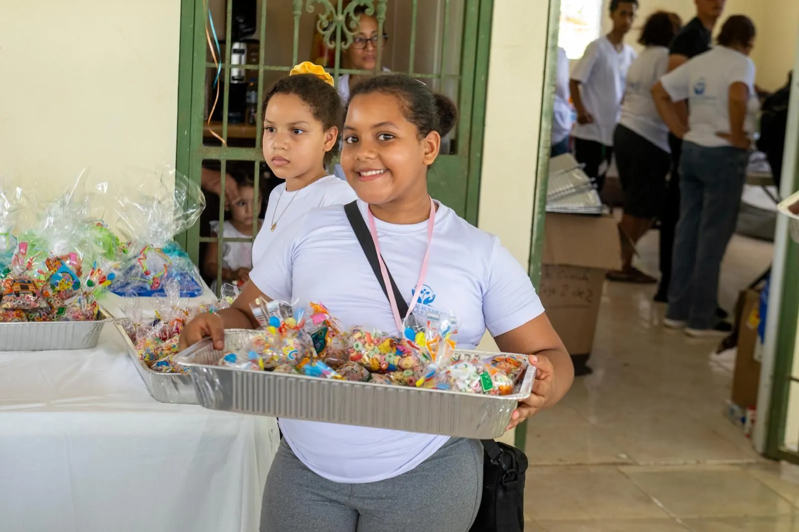 A young volunteer carrying a tray of treat bags